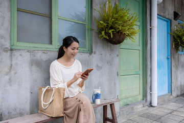 Tourist woman use mobile phone at old style house in Taipei city