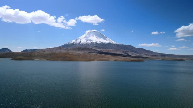 Aerial view over Chungara Lake and Parinacota volcano, Chile - dolly forward rising, drone shot