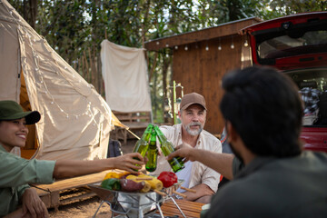 Group tourists drinking beer-alcohol and play guitar together with enjoy and happiness in Summer while camping