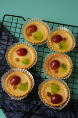 fruit pie on a cooling rack. delicious and healthy dishes. there are kiwi chunks, grapes, and raisins. on the Tosca color table.