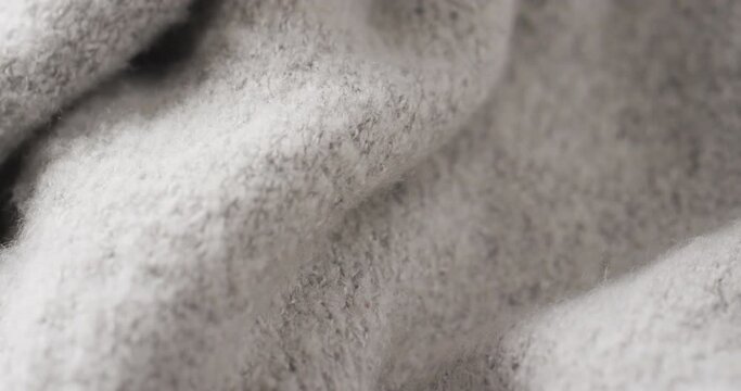 Micro video of close up of grey wooly fabric with copy space