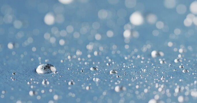 Micro video of close up of water drops with copy space on blue background