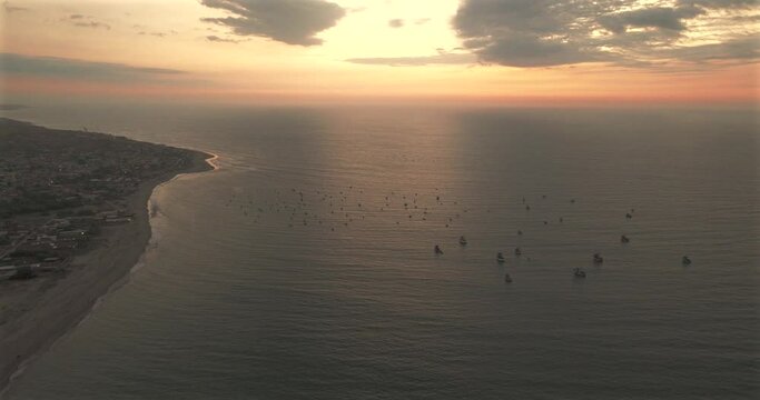 Aerial view of beautiful sunset behind in the ocean fishing boats.