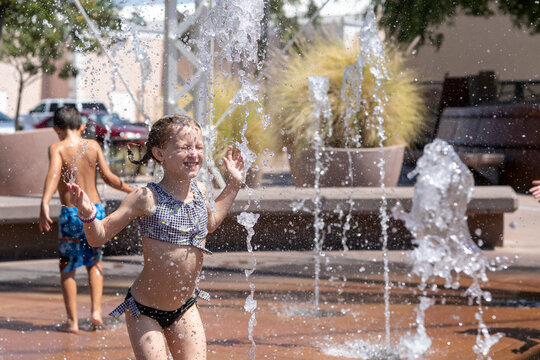 Young girls enjoys playing in water on splashpad