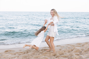 Mother's love for daughter. Mother and daughter play near the sea