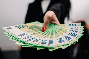 Young woman business lady in chic suit stylishly dressed holding a good amount of euros. Business...