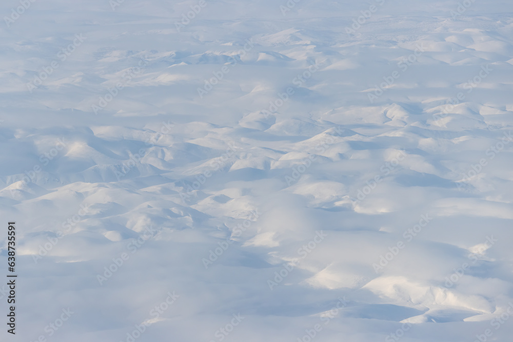 Wall mural Aerial view of snow-capped mountains and clouds. Winter snowy mountain landscape. Icheghem Range, Kolyma Mountains. Koryak Okrug (Koryakia), Kamchatka Krai, Siberia, Far East Russia. Great background.