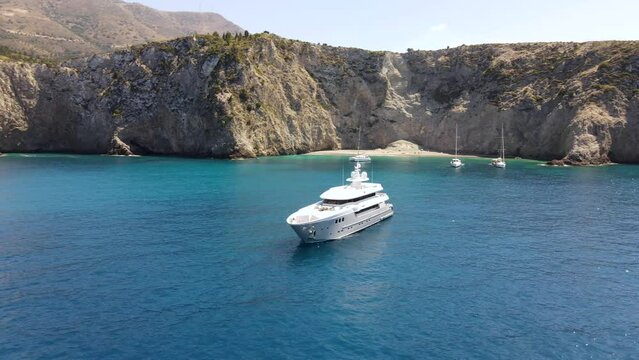 Large yacht docked in remote beach bay, coast of Asos in Greece, scenic panorama