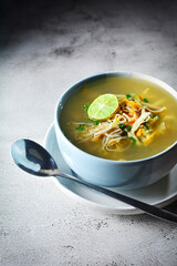 soto ayam, soto ayam or chicken soto is indonesian traditional food served on bowl in grey and texture background. soto ayam kudus.