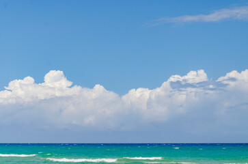 Blue sky and fluffy clouds over a blue sea