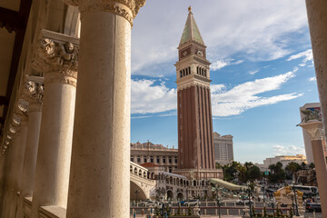 Scenic view of replica bell tower of luxury hotel Venetian seen through majestic white stone pillars on the  Las Vegas Strip, Nevada, USA. Gambling, party, freedom and no limits concept - obrazy, fototapety, plakaty