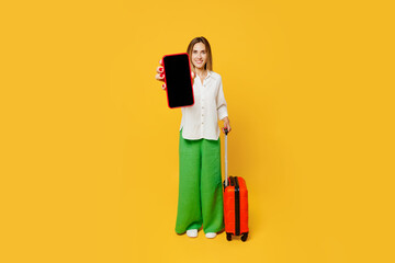 Traveler woman wearing white casual clothes hold suitcase blank screen mobile cell phone isolated...