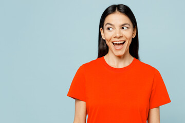 Young surprised impressed amazed cool fun latin woman wear orange red t-shirt casual clothes look...