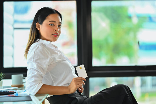 Confident Young Woman With Credit Card In Her Hand, Looking At Camera. E-commerce, Banking Service And Shopping Online