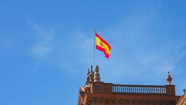 Spanish flag waving on top of one of the towers of Plaza de Espa&ntilde;a in Seville