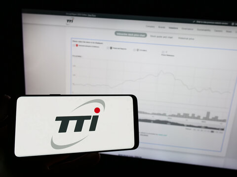 Stuttgart, Germany - 08-15-2023: Person holding mobile phone with logo of Techtronic Industries Company Limited (TTI) on screen in front of web page. Focus on phone display.