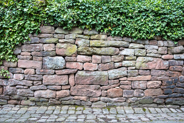 Granite stonewall and cobblestone background texture.