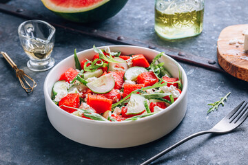 Watermelon salad with cucumber, arugula and feta cheese on old galvanized background.