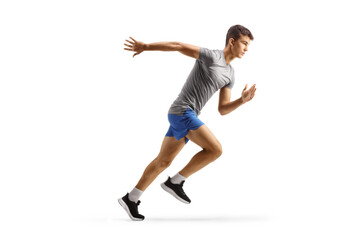 Fototapeta na wymiar Full length profile shot of a fit male teenager running