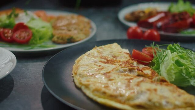 omelet with tomato and salad on a plate and other breakfasts in the restaurant