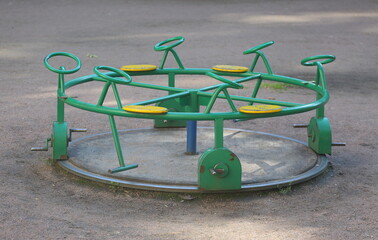 Round green metal children's carousel on the playground