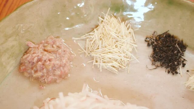 미나리,파,새우젓,잣,청각, 생강 등 백김치를 만드는 재료와 갖은 재료를 버무려 백김치를 만드는