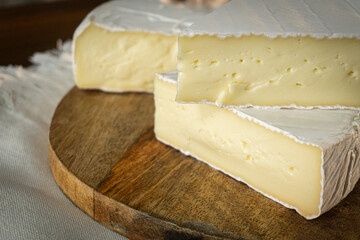 Camembert and brie cheese on wooden background with nuts, honey and fruits. Dairy products.