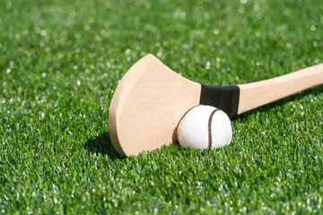 Hurling bat and sloitar on green grass. Horizontal sport theme poster, greeting cards, headers, website and app