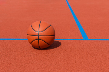 New orange basketball with blue line on orange court of gymnasium sport floor. Horizontal sport theme poster, greeting cards, headers, website and app