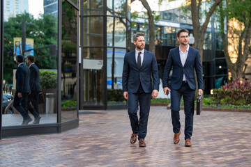 Business men walking across the street on american city outdoor. Businessmen great partnership. Businessmen were constantly learning and growing.