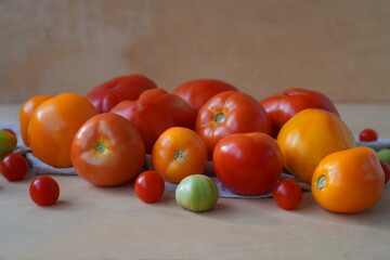 vegetables in the form of tomatoes of different colors and sizes, grown independently on a garden plot for winter preparations on a wooden table. The concept of growing eco-friendly food at home