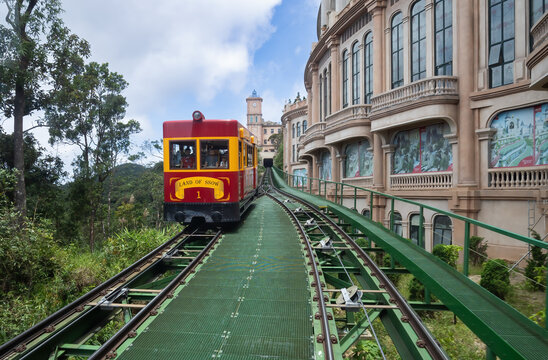 DANANG, VIETNAM - AUGUST 16, 2023: Automated electric train in Ba Na Hills mountain resort, landscape is castles covered with train at the top, the famous tourist destination of Da Nang, Vietnam.