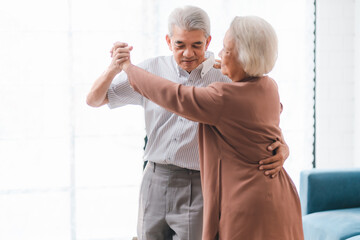 Asian happy senior couple having fun and relax dancing together at home, love, romantic elderly...