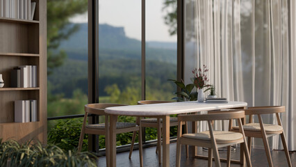 A dining table in a modern dining room with a large window with an amazing mountain view.