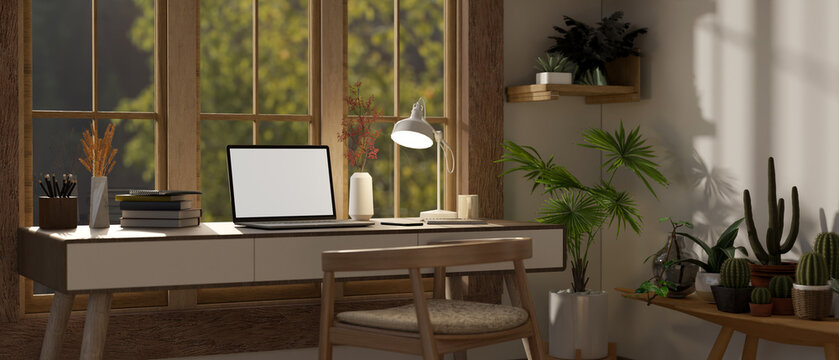 A cozy, minimalist home workspace with a laptop on a table against the window