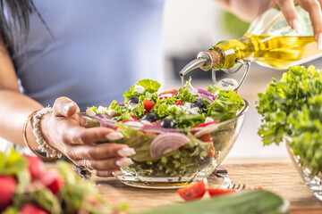 The final preparation of a healthy salad and at the end the woman pours olive oil