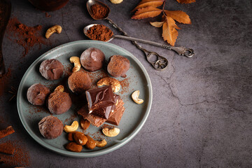 Pieces of chocolate and nuts in a plate on a dark background