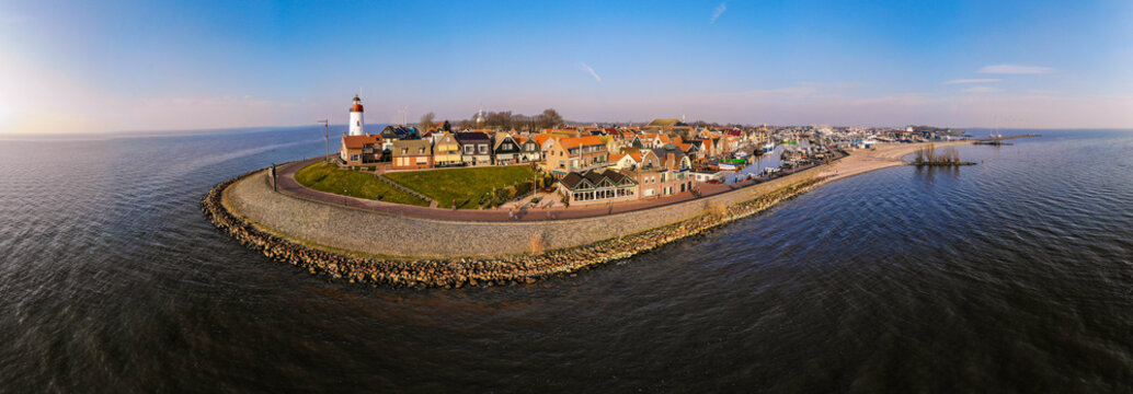 Urk Flevoland Netherlands sunset at the lighthouse and harbor of Urk Holland. Traditional Fishing Village Urk. Beautiful sunset during the evening, drone aerial view