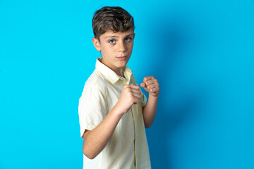 Beautiful kid boy wearing casual shirt Ready to fight with fist defense gesture, angry and upset...