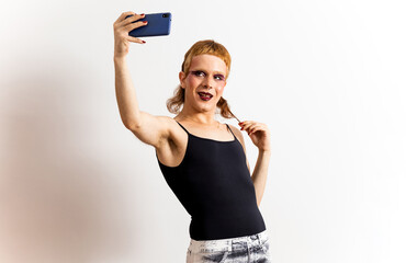 A red-haired non-binary person is posing on a white background in extravagant clothing and takes a...