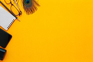 Creative Wallpaper with some stationary items on a yellow background. Flat lay, top view.