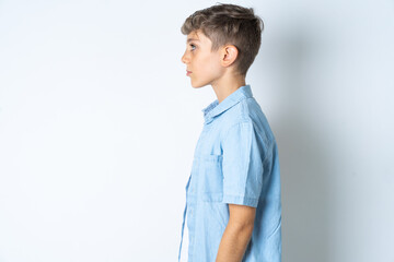 Beautiful kid boy wearing  casual clothes looking to side, relax profile pose with natural face with confident smile.