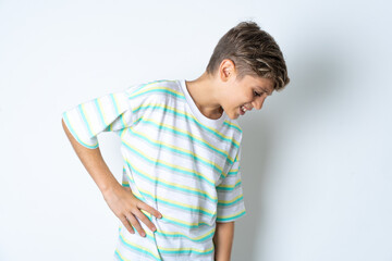 Beautiful kid boy wearing striped casual t-shirt Suffering of backache, touching back with hand, muscular pain