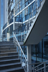 empty Modern design metal staircase with concrete and glasses office building. iron Railings and...