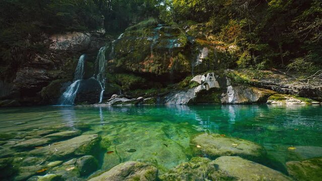 4K UHD Cinemagraph seamless video loop of Virje waterfall at mountain river Soča in Triglav National park in Slovenia. Idyllic scenic Slovenian alps cascade. Clear blue green water, moss and rocks.