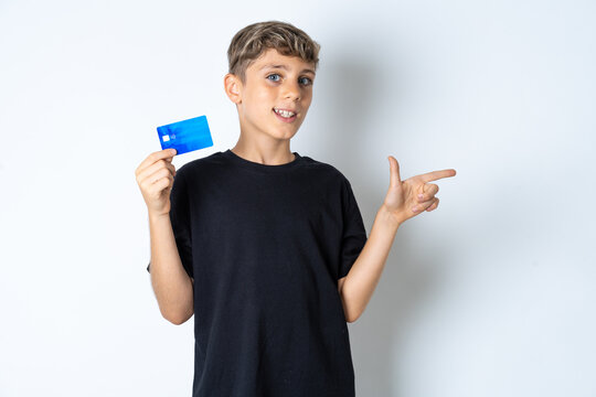 Curious smiling Beautiful kid boy wearing black casual t-shirt showing plastic bank showing finger copyspace