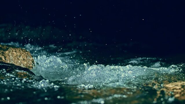 Slow motion ripple waves on dark water river.Super slow motion detail 4k video.Amazing dramatic night cinematic backgrounds.Epic mystical magic night view.Underwater stones.Crystal clear spring river