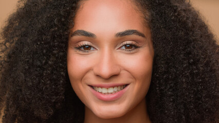 Close up female perfect face clean smooth skin make-up smiling happy African American woman model girl beautiful lady smile at camera posing in studio beauty skincare fashion headshot look to side