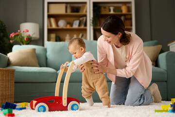 Joyful mother and baby boy playing with toys on a carpet at home