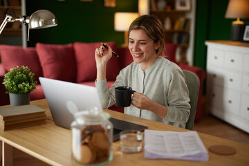 Happy female freelance professional working from home on laptop